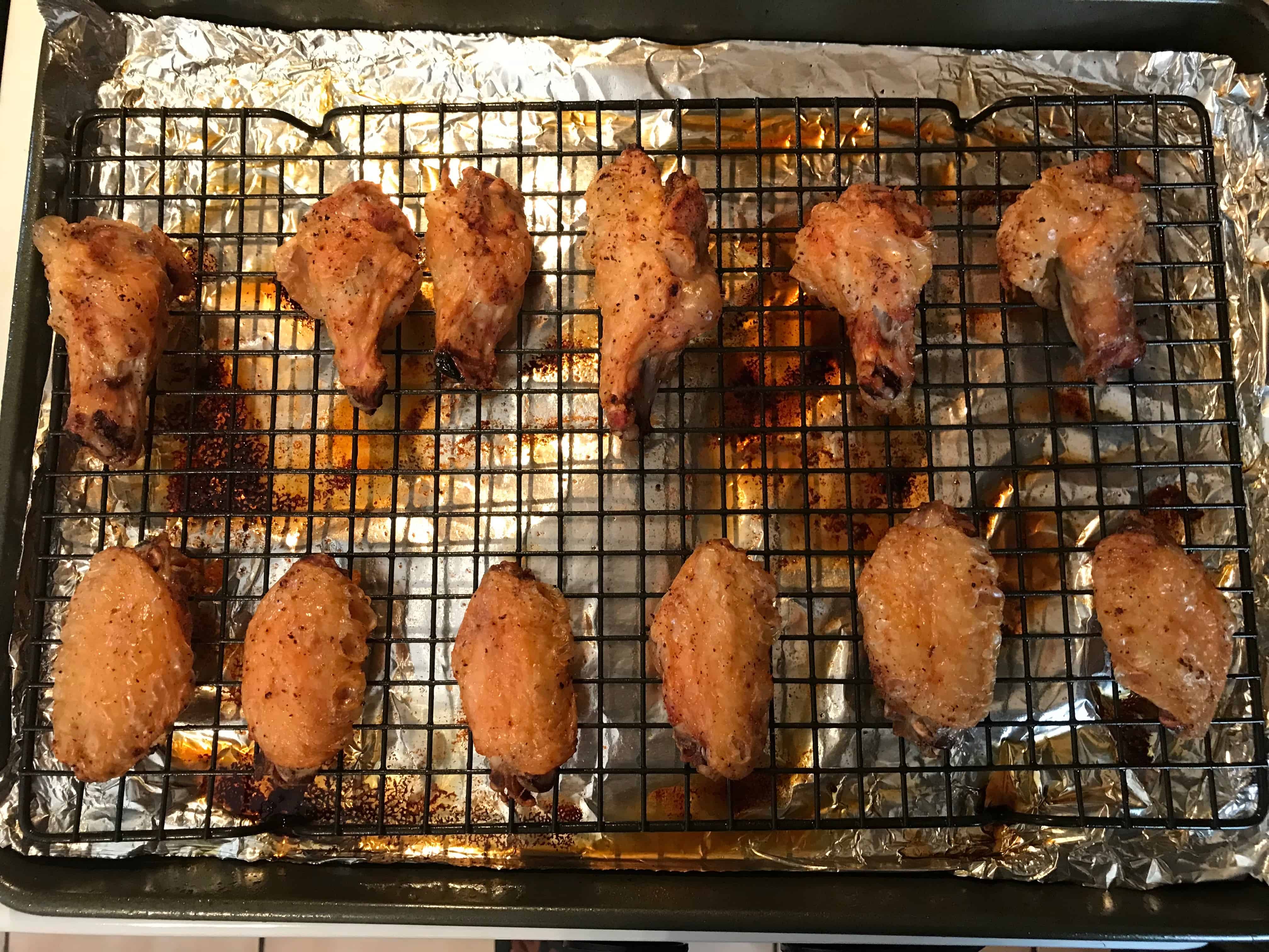 Cooked chicken wings on baking rack