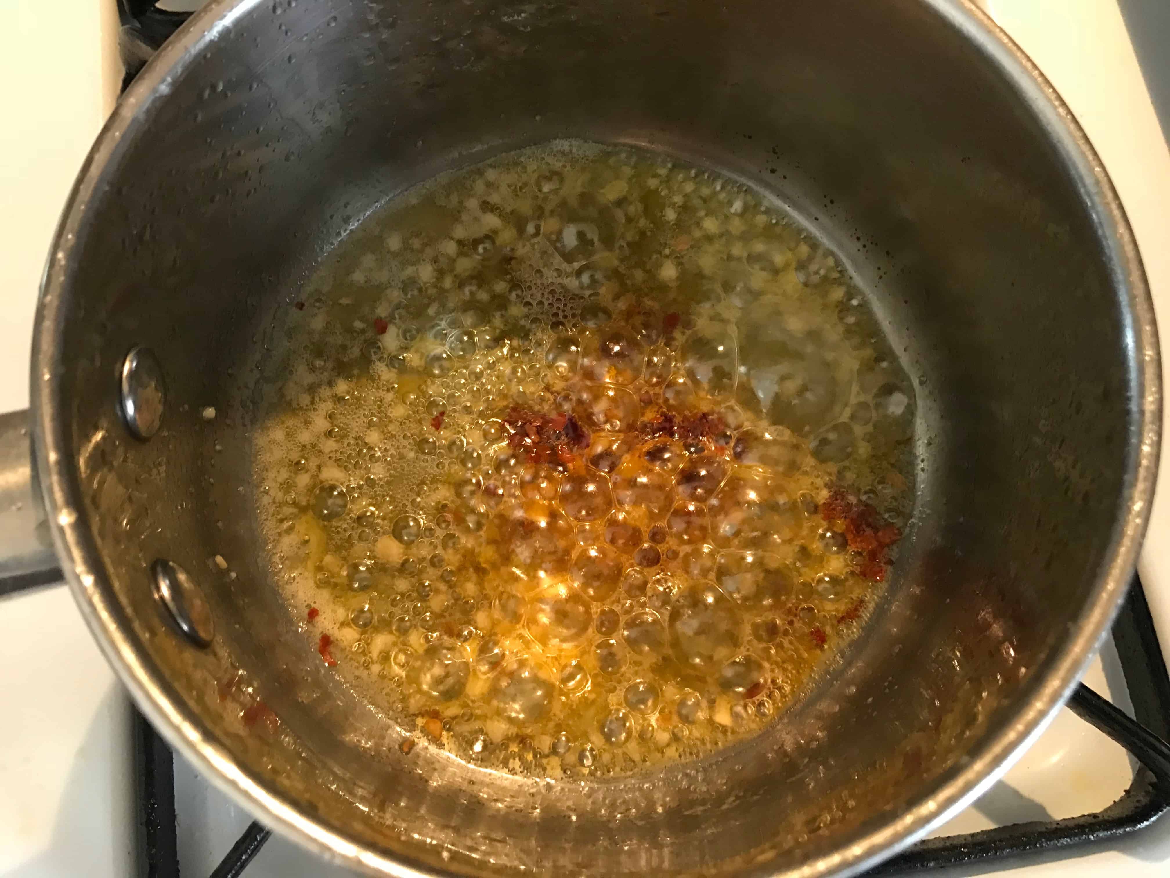 Adding garlic and seasoning to hot butter