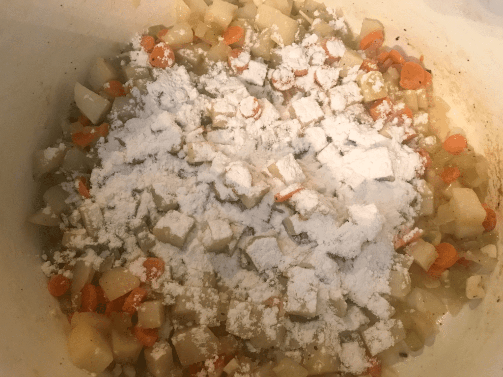 Add flour to veggies in potatoes