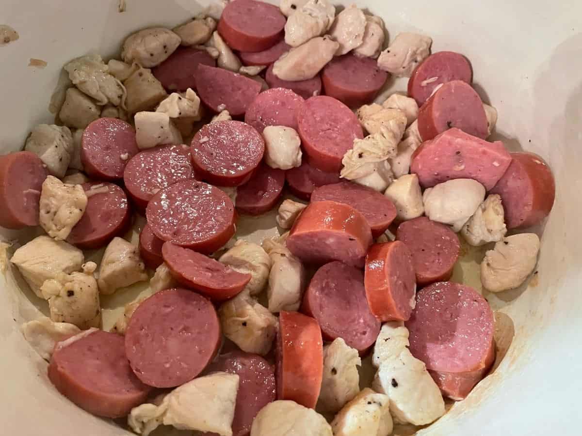 Chicken and sausage cooking in a dutch oven