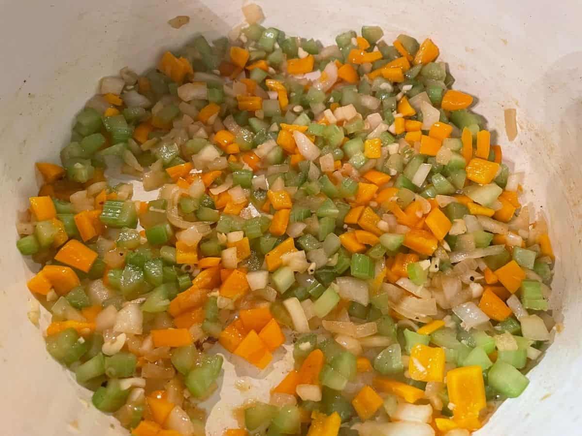 celery, onion, bell pepper, and garlic cooking in dutch oven