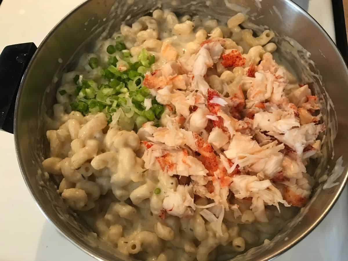 green onion, lobster, and mac and cheese in a pot