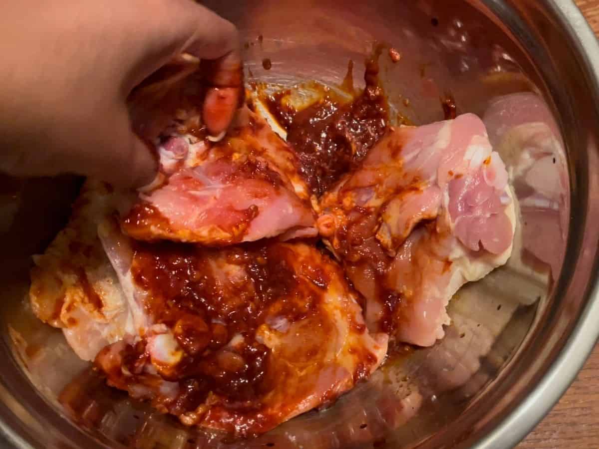 Mixing marinade on chicken thighs