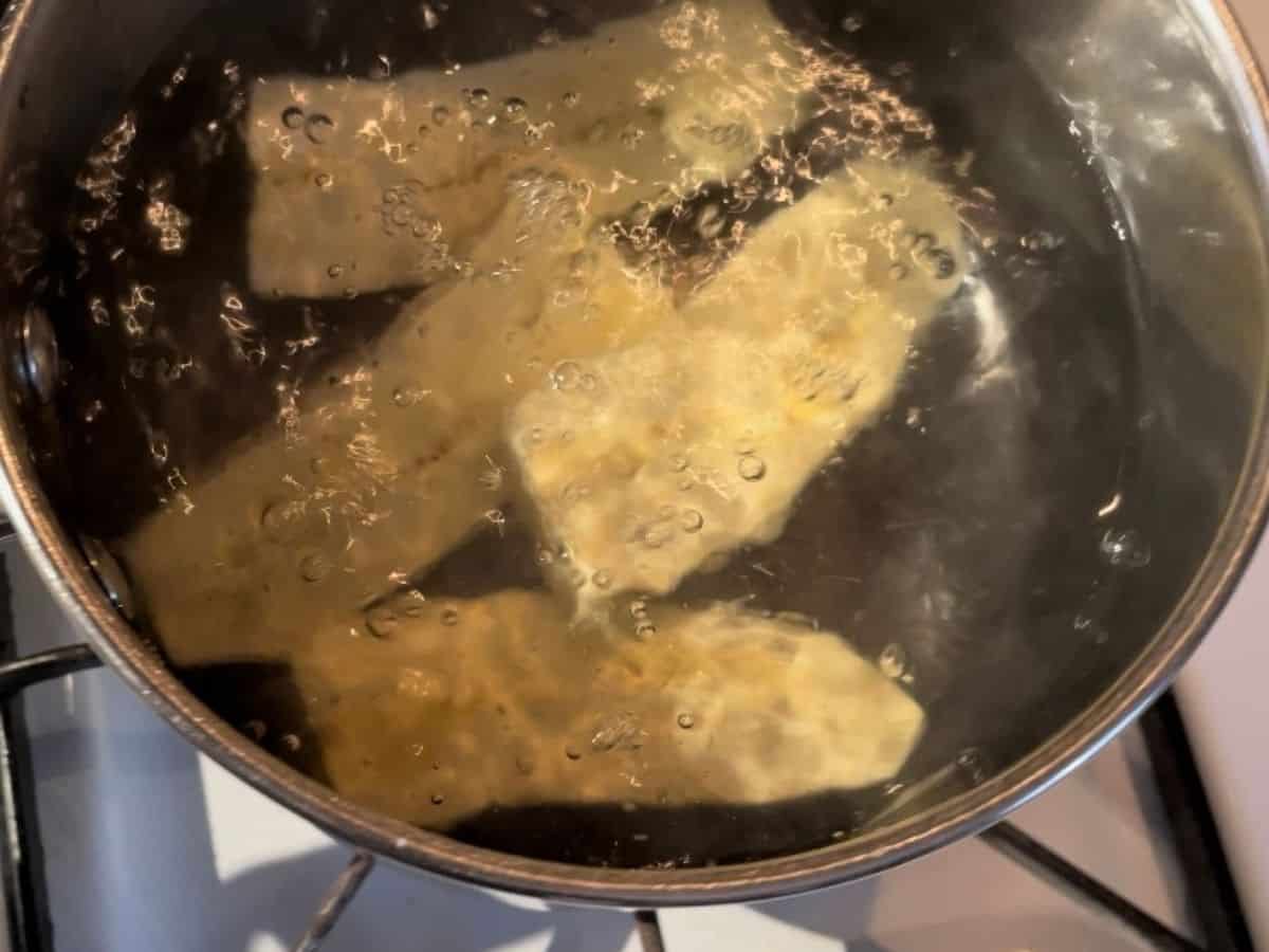 sliced green plantains in boiling water