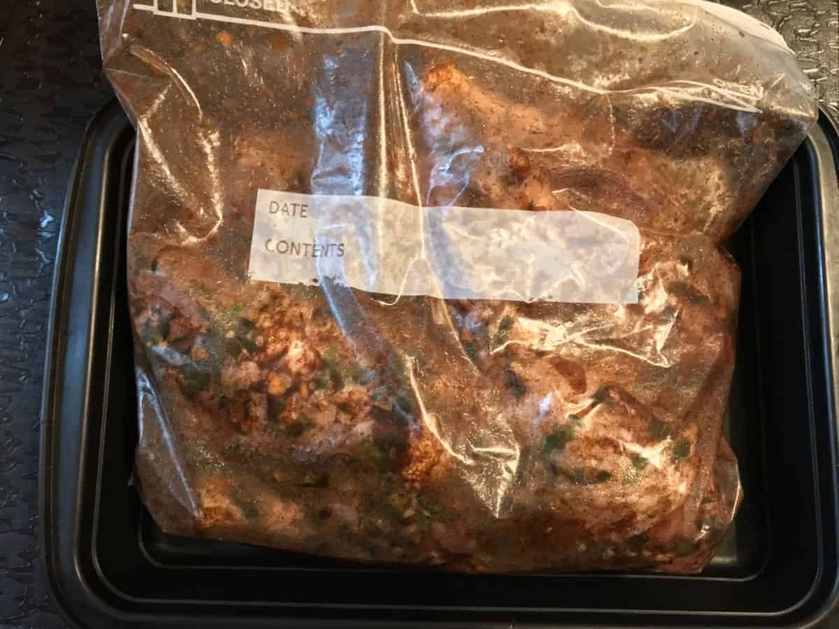 chicken marinating in jerk sauce in resealable bag