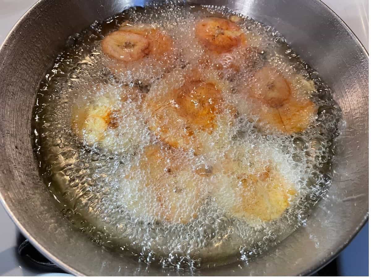 flattened plantains frying in hot oil