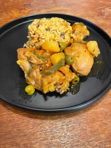 pollo guisado served with arroz con gandules on plate