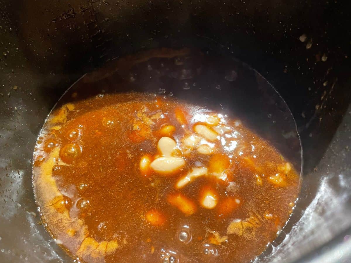 Oxtail gravy cooking in instant pot with butter beans