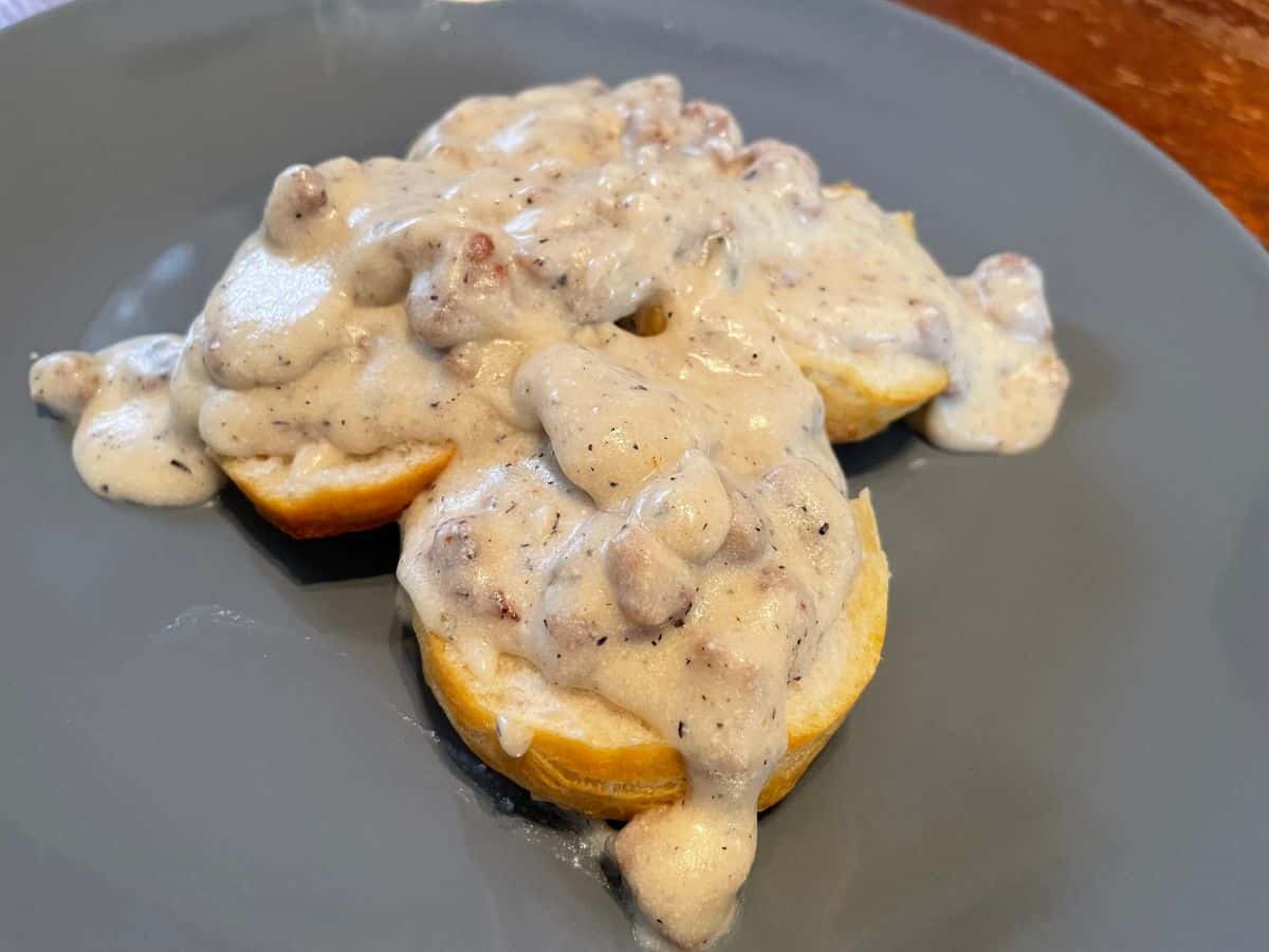 sausage gravy on top of biscuits on a blue plate