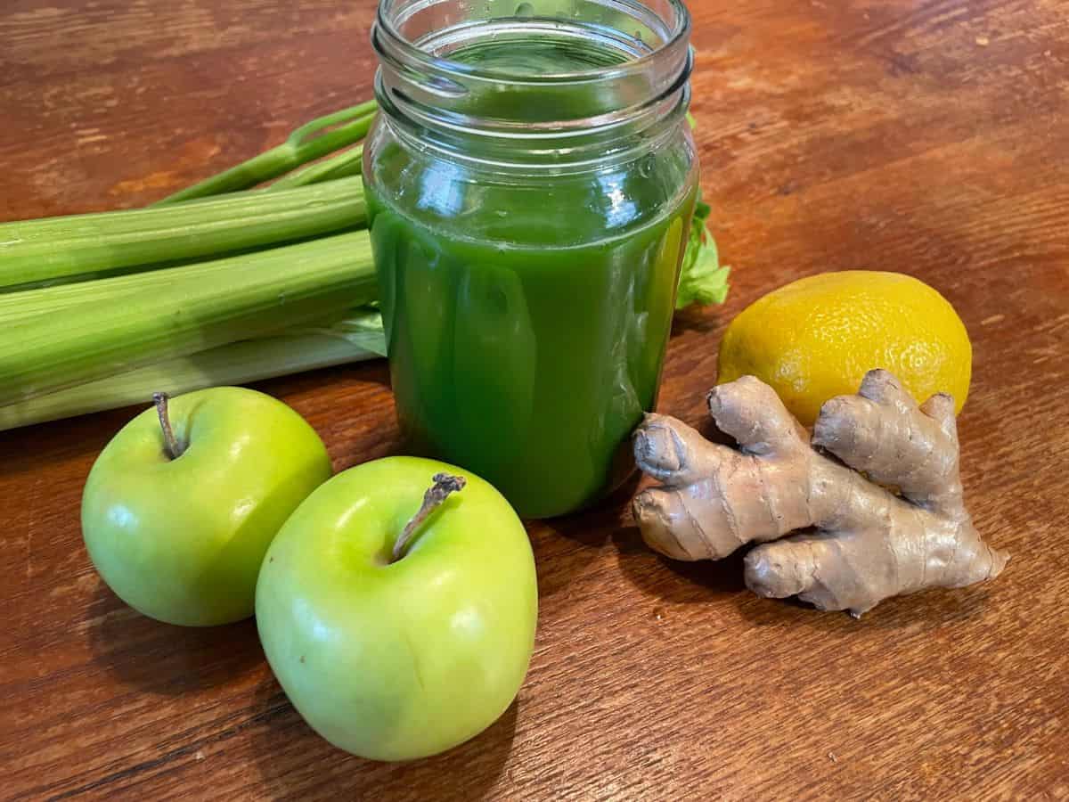 mason jar of green juice with ingredients around the glass