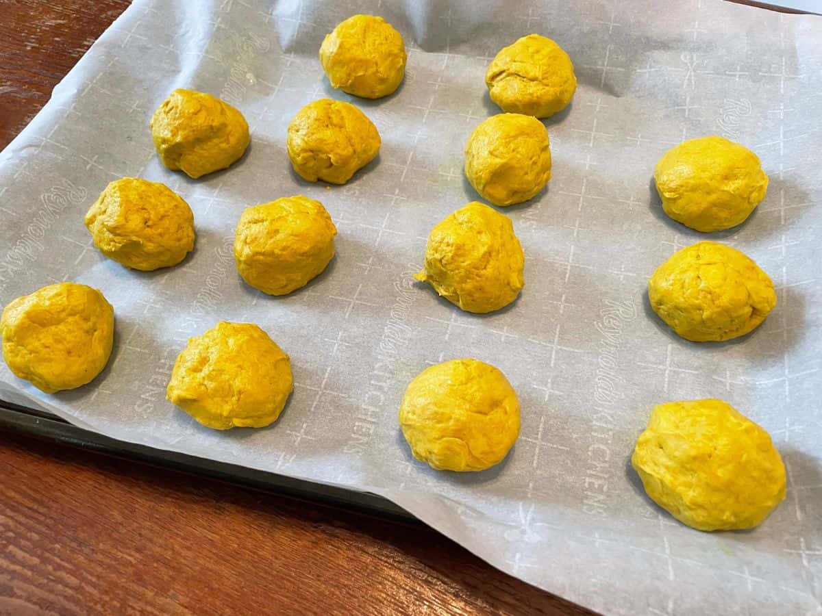 small balls of dough on a parchment paper lined baking sheet