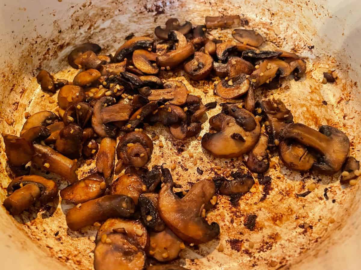 mushrooms and garlic cooking in a dutch oven