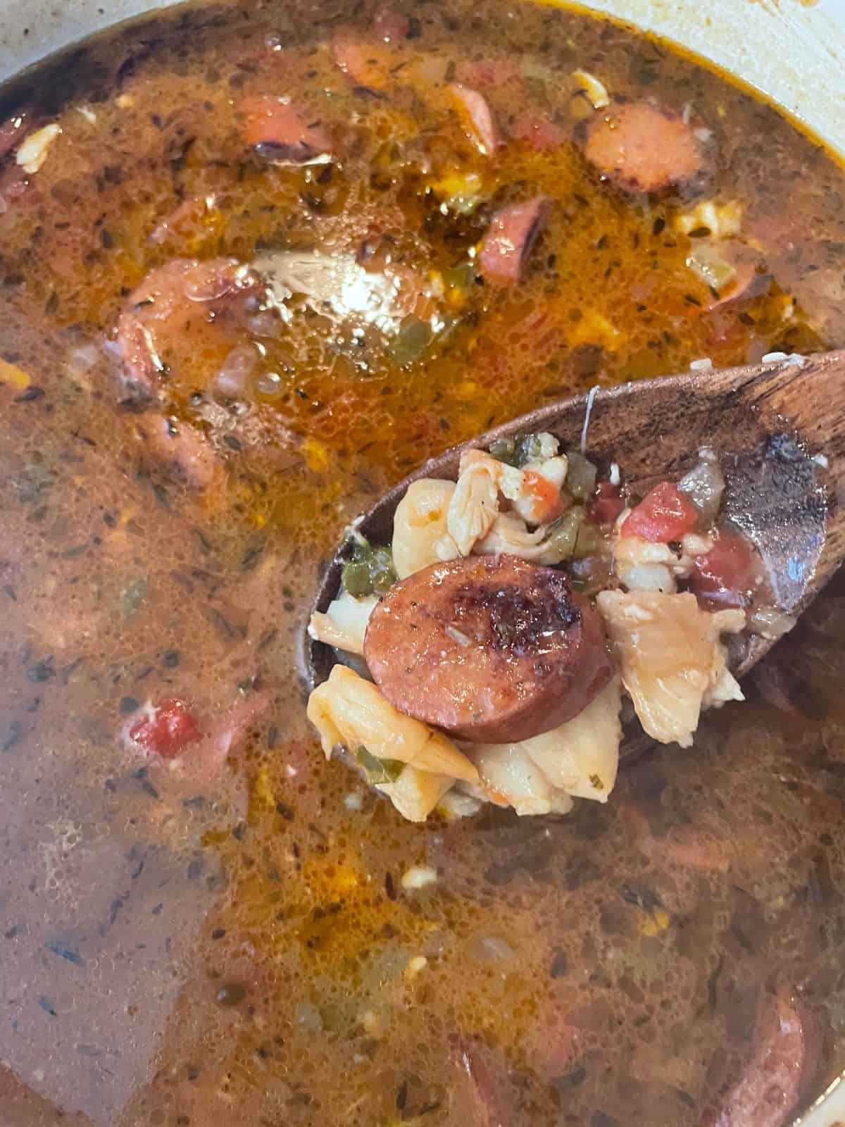 spoonful of seafood gumbo over gumbo pot