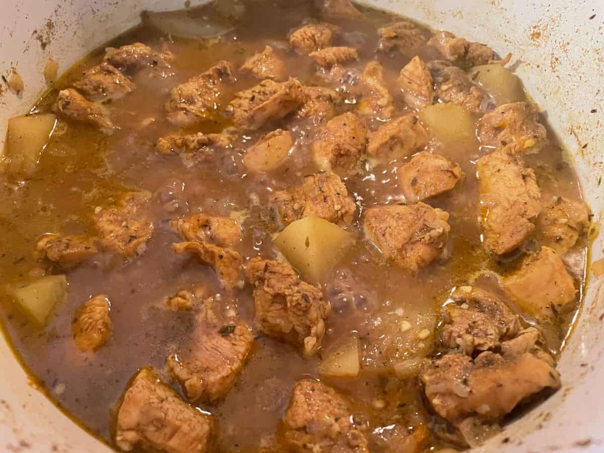 curry chicken simmering in dutch oven