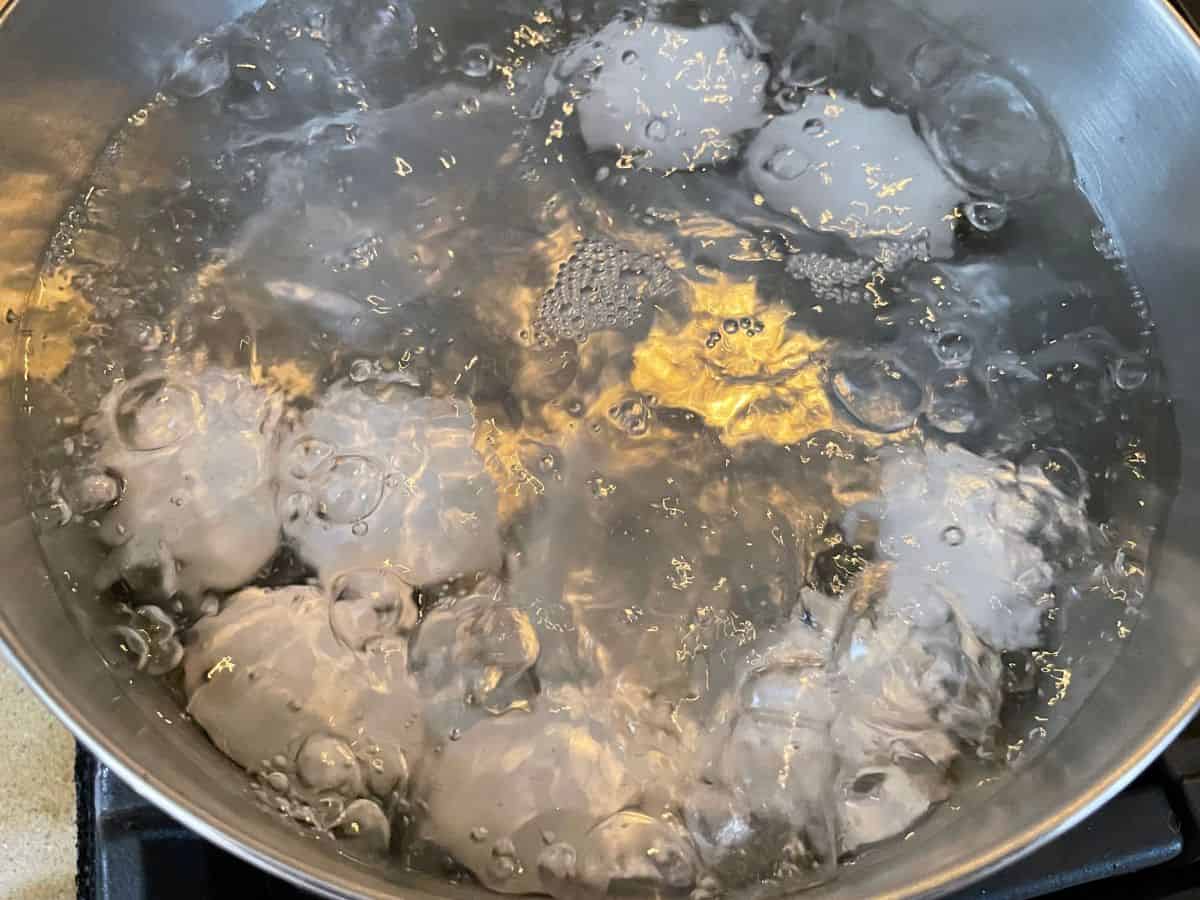 Eggs boiling in a large pot of water