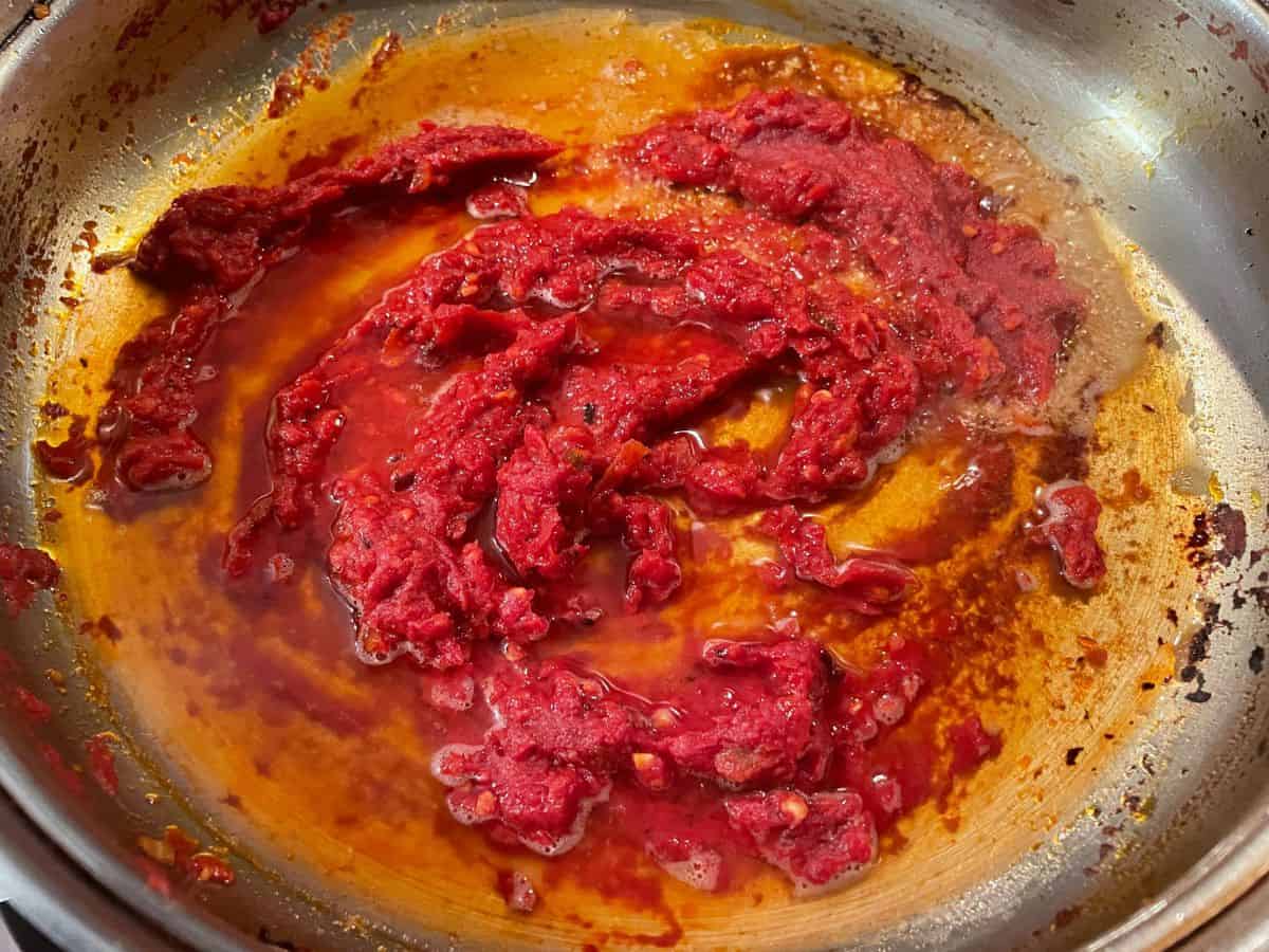 vodka added to tomato paste mixture in pan