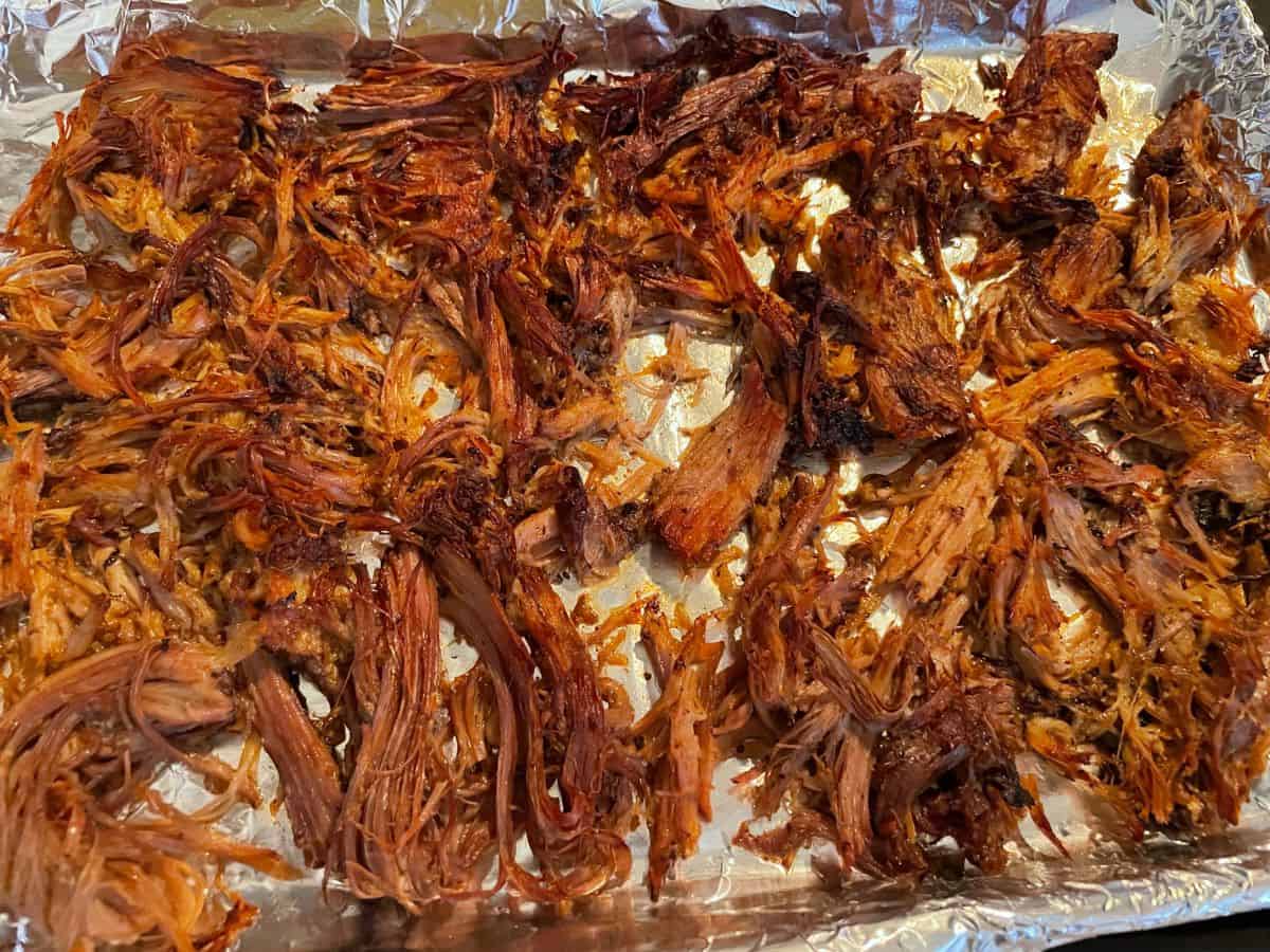 broiled shredded pork on a foil lined sheet tray