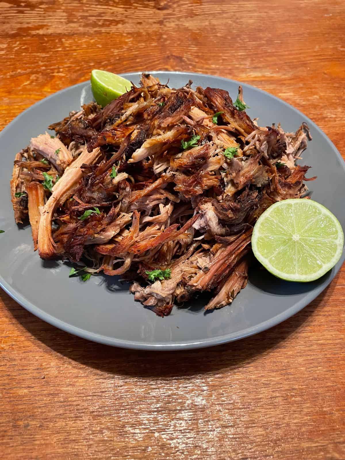 carnitas garnished with cilantro and lime
