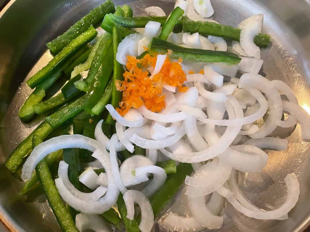peppers and onions cooking in a skillet